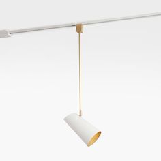 a white light hanging from a ceiling with a gold colored metal fixture on it's side