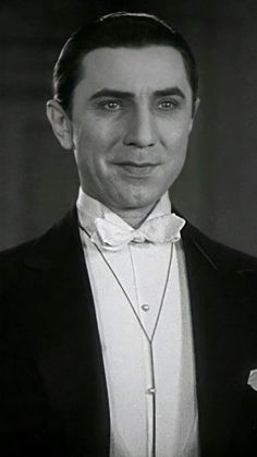 a man in a tuxedo and bow tie is smiling at the camera with his eyes wide open