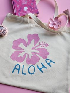 Hand-Painted Canvas Tote Bag - Hibiscus Flower & Aloha Design Bring a splash of tropical beauty and artistry to your everyday style with our hand-painted tote bag, featuring a vibrant Hibiscus flower and "Aloha" typography. Crafted from durable terylene cotton, this unique tote measures 41x40 cm (16x15.7 inches), offering plenty of space for all your essentials. Key Features: Original Design: Each tote bag features an exclusive, hand-painted Hibiscus flower and "Aloha" design, created with high- Tote Bag Inspo Painting, Cute Tote Bag Design Paint, Flower Tote Bag Design, Cute Tote Bag Design, Hibiscus Tote Bag, Painting Tote Bags, Painted Tote Bag, Painted Canvas Bags, Tote Bag Designs