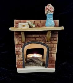 a ceramic fireplace with a lit candle in it