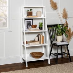 a white shelf with books and plants on it