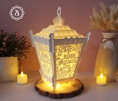 a lit up lantern sitting on top of a table next to some vases and flowers