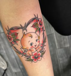 a small tattoo on the arm of a girl with flowers and a teddy bear in it