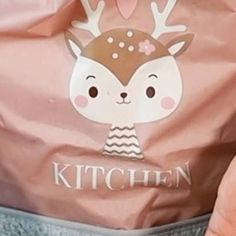 a person holding a pink bag with a deer on it's head and the words kitchen printed on it