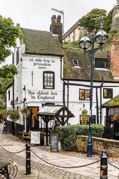 the oldest inn in england is situated on an old cobblestone street with trees and buildings around it