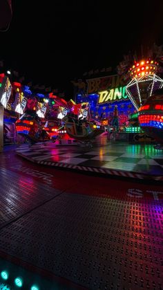 an amusement park at night lit up with neon lights