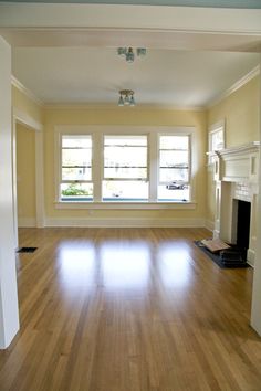 an empty living room with hard wood floors and white trim on the windowsills