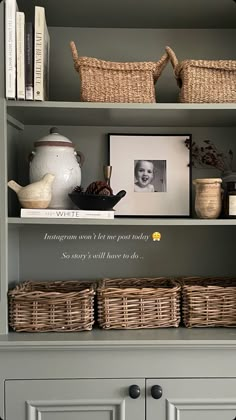 a book shelf with baskets and pictures on it, next to a cabinet filled with books