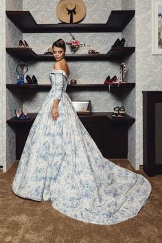 a woman in a blue and white dress standing next to shelves