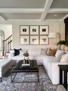 a living room filled with furniture and pictures on the wall