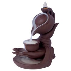 a figurine is pouring milk into a cup on top of a saucer