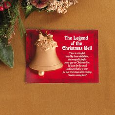 the legend of the christmas bell is on display next to flowers and a card that reads,'the legend of the christmas bell '