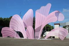 a large pink sculpture sitting on the side of a road