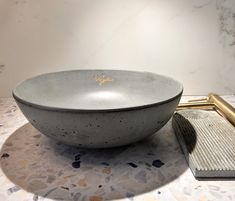 a bowl sitting on top of a table next to a brush