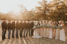 a group of people standing next to each other in a field with trees and grass