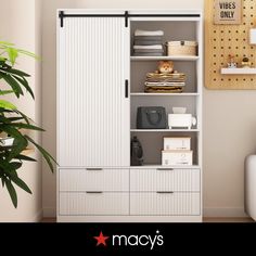 a white closet with sliding doors and drawers next to a plant in a living room