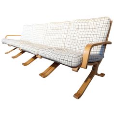 a white and brown couch sitting on top of a wooden frame