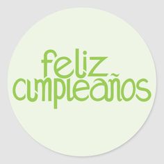 the word feliz cumpleanos in green on a white circle sticker