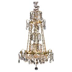 a gold chandelier with crystal drops hanging from it's centerpieces