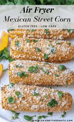 air fryer mexican street corn on a white plate with lemons and parsley