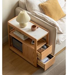 a small table with two drawers and a lamp on the end shelf next to it