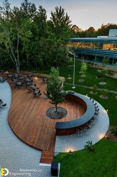 an aerial view of a park with benches and tables in the center, surrounded by green grass