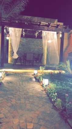 an outdoor patio with lights and flowers at night