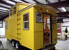 a yellow tiny house sitting inside of a building