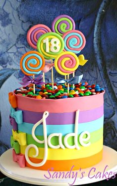 a colorful birthday cake decorated with lollipops and candy