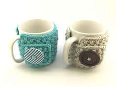 two knitted coffee mugs sitting next to each other