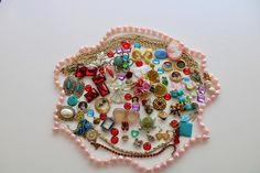 a white table topped with lots of different types of beads and jewelry on top of it