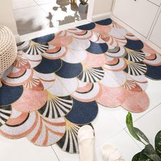 a pair of slippers sitting on top of a rug next to a potted plant