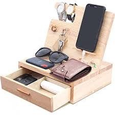 an open wooden box with sunglasses, cell phone and other items in it on a white background