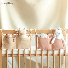 two baby cribs with stuffed animals hanging from them