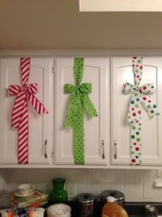 the kitchen cabinets are decorated with bows and polka dot ribbones for christmas decorations, as well as other holiday items