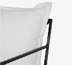 a white pillow sitting on top of a black metal frame