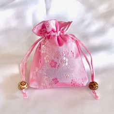 a pink bag with gold bells on it