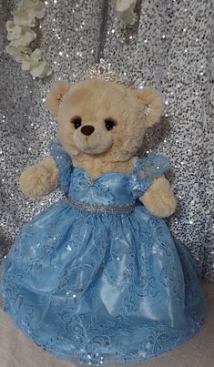 a teddy bear dressed in a blue dress