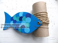 a blue fish on a roll of twine next to a toilet paper roll holder