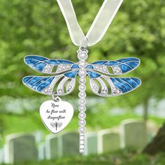 a blue and white dragonfly ornament hanging from a tree with a heart