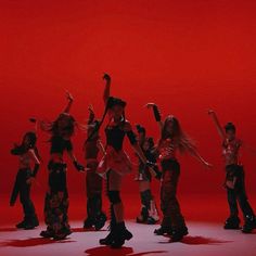 a group of young women standing next to each other in front of a red background