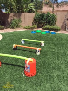 an outdoor play area with plastic buckets and obstacles