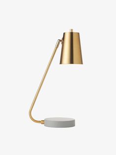 a gold lamp with a white base on a white background, the light is turned on