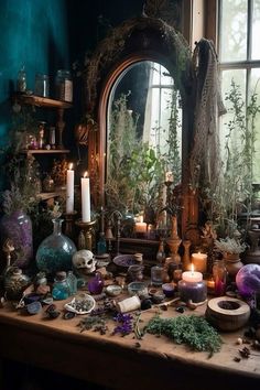 a table topped with lots of vases and candles next to a window filled with plants