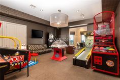 a room with arcade machines and couches inside of it in front of a flat screen tv