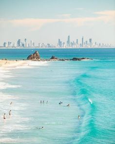 people are swimming in the ocean and on the beach