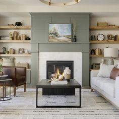 a living room filled with furniture and a fire place in the middle of a room