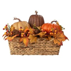 a basket filled with lots of different types of pumpkins and autumn leaves on top of it