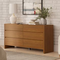 a wooden dresser sitting in front of a white brick wall