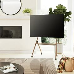 a flat screen tv mounted to the side of a wall in a living room next to a fire place